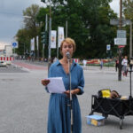 Nahaufnahme von Carolin Schiml, die eine Rede zum Erhalt des 9-Euro-Tickets vor dem Regensburger Bahnhof hält