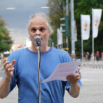Kurt Raster hält eine Rede zum Erhalt des 9-Euro-Tickets vor dem Regensburger Bahnhof